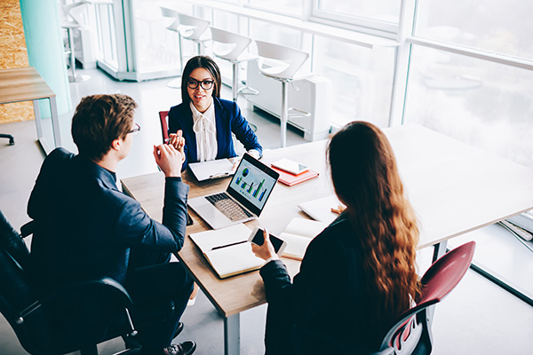 Three people at a meeting table